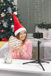 Full length of woman with christmas tree in winter