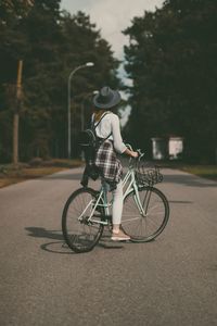 Rear view of woman cycling on street