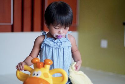 Baby girl playing with toy at home