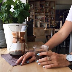 Close-up of hands preparing coffee on table