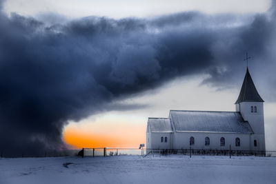 Built structure on snow covered landscape against sky
