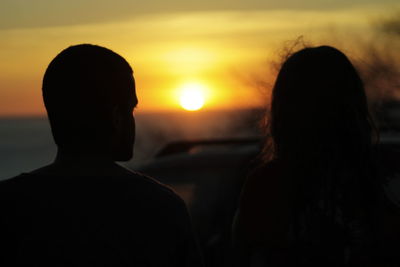 Rear view of silhouette couple against sky during sunset