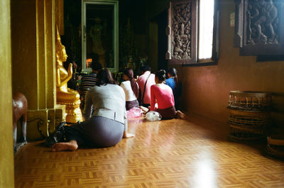 Rear view of people sitting on floor at home