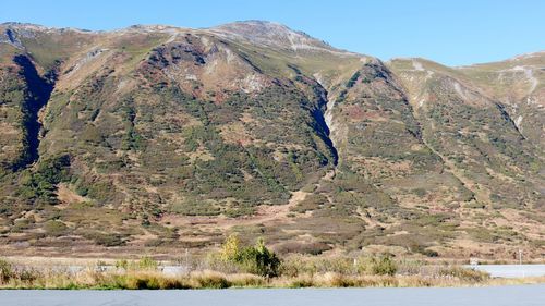 Scenic view of land and mountains against sky