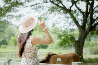 Rear view of woman wearing hat while standing outdoors