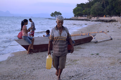 Rear view of people standing on beach