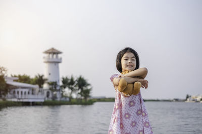 Portrait of a girl standing against the sky