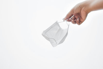 Close-up of hand holding umbrella against white background