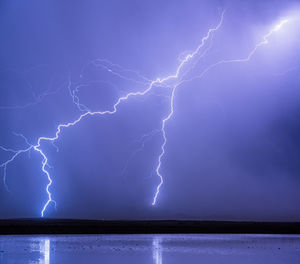 Lightning striking behind a small pond near willcox, arizona