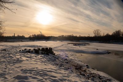 Scenic view of frozen lake against sky during sunset