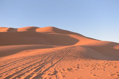 Scenic view of desert against clear blue sky