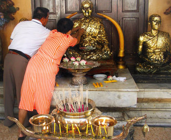 Midsection of man statue in temple outside building