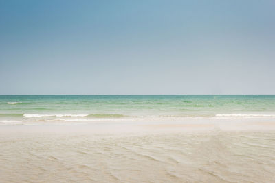 Scenic view of beach against clear blue sky