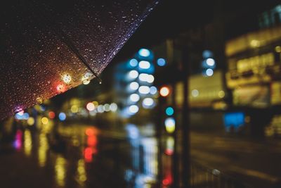Wet umbrella against street during rainy season at night