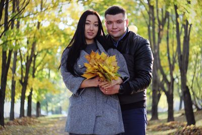 Young couple kissing against plants