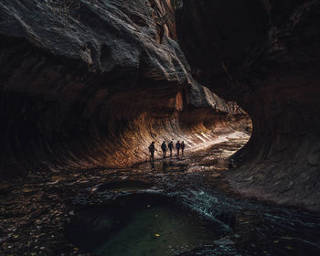 Silhouette people walking in cave