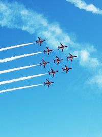 Low angle view of airshow against blue sky