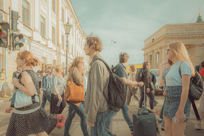 Rear view of people walking on street in city