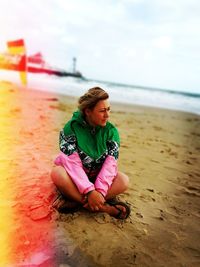 Full length of woman sitting on beach