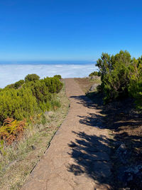 Scenic view of path leading into the sky