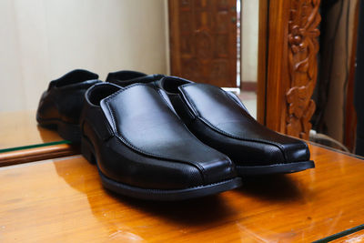 Close-up of shoes on wooden floor at home