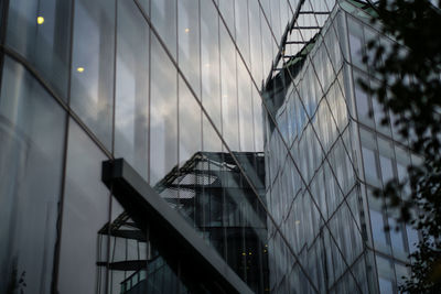 Low angle view of glass building against sky