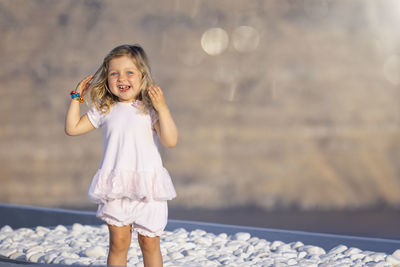 Full length of smiling girl standing outdoors