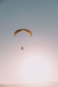 Low angle view of paragliding against clear sky