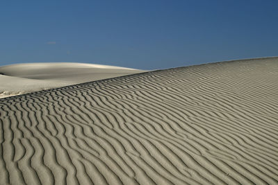 Sand dunes against clear sky