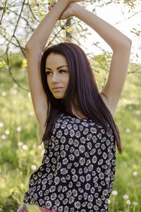 Young woman wearing floral top while looking away