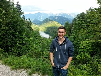 Portrait of smiling man standing in forest
