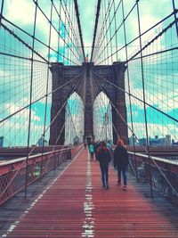 Rear view of people walking on footbridge