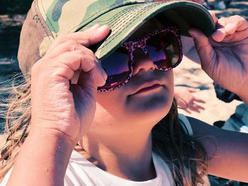 Close-up portrait of woman holding sunglasses