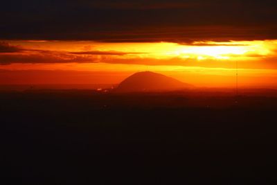 Scenic view of silhouette mountain against orange sky