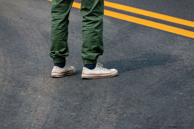 Low section of man standing on roadside