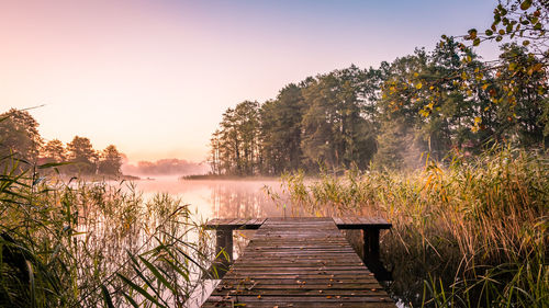 Pier over lake against clear sky