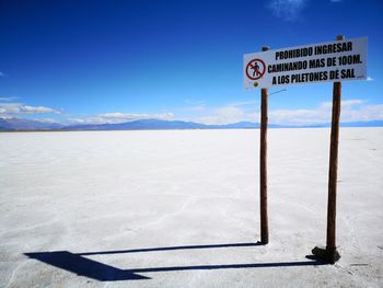 Information sign on road against blue sky