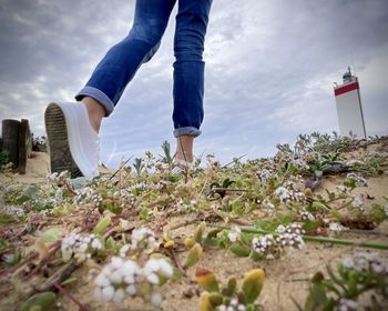 Low section of woman walking on field