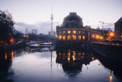 Reflection of buildings in city at dusk