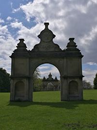 Built structure on landscape against cloudy sky