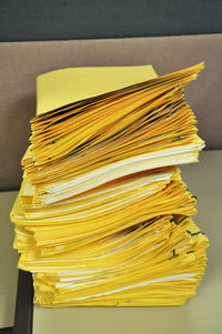 Close-up of yellow papers on table in office