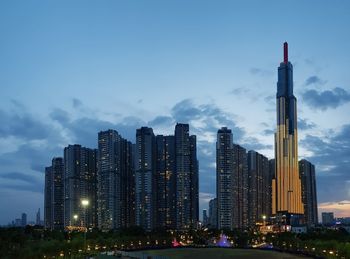 Illuminated buildings in city against sky