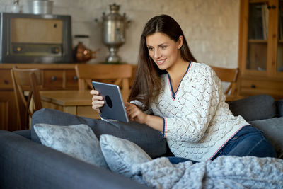 Woman watching video in digital tablet at home