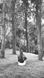 Woman sitting on tree trunk