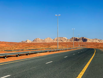 Road by street against blue sky