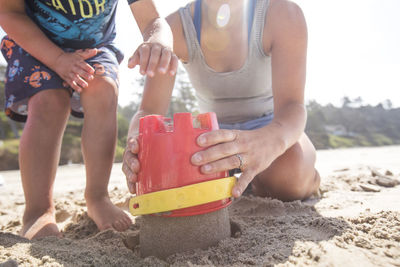 Low angle of mother and son building sand castle.