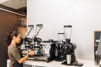 Side view of barista working at cafe