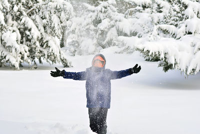 Young boy with arms outstretched in snow