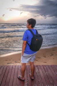 Rear view of boy standing on beach