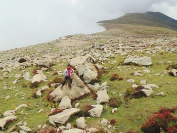 Person standing on mountain against sky